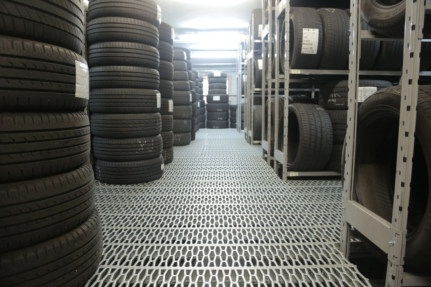 Rows of stacked tyres in an industrial warehouse